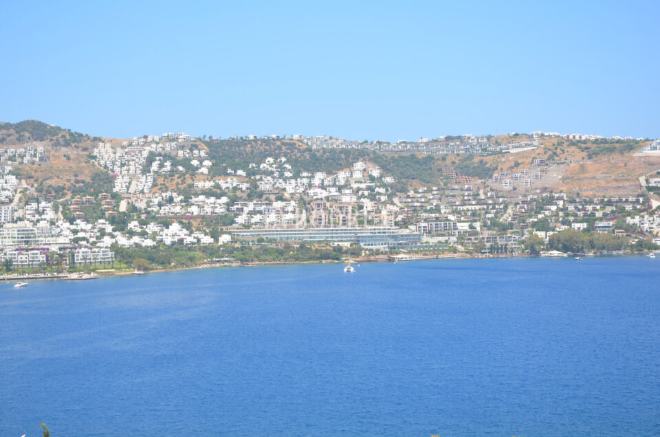 Gündoğan bay: white houses spread across the slope above a calm, sheltered blue bay