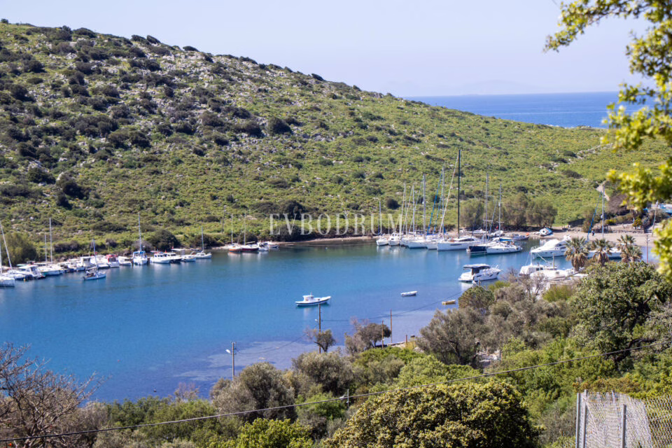 Gümüşlük bay: a sheltered harbour with moored sailing boats and the Aegean islands behind